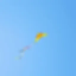 A colorful remote control kite soaring high against a clear blue sky