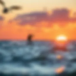 A kiteboarder gliding over the waves during sunset.