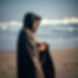 A kiteboarder using a hooded change towel on the beach after a session