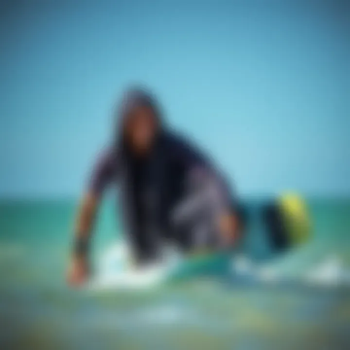 A kiteboarder transitioning from water to land while wearing a hooded change towel